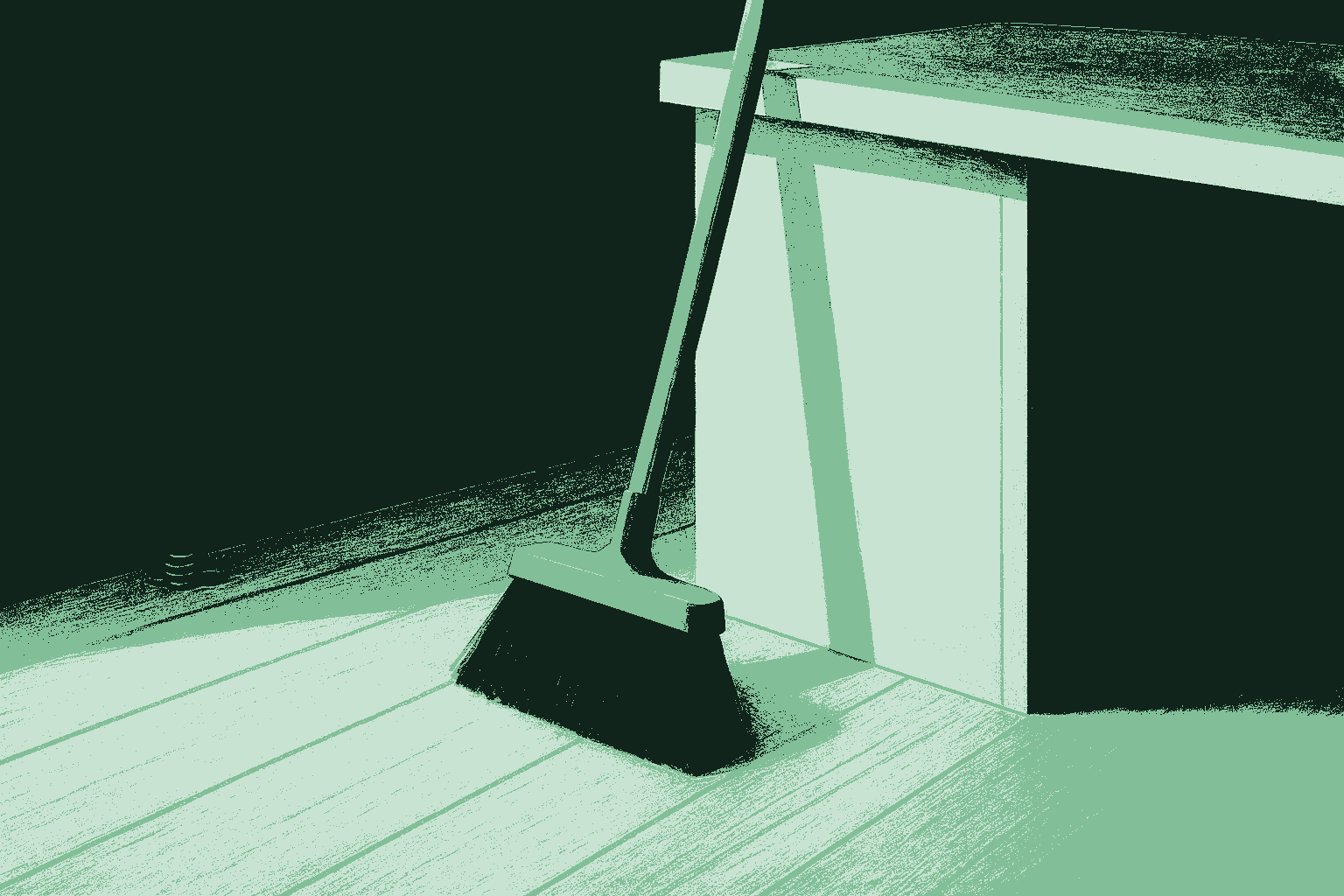 A quiet, freshly swept wooden office floor at the end of the day. A single wide broom leans against the side of a desk, and the floor is clean and bare except for one small neat pile of coins gathered against the baseboard, saved rather than lost, suggesting the calm after-state of cleaning up the mess around the work.