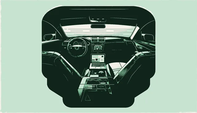 Interior of a car with a laptop visible underneath the passenger seat in shadow with green light through the windshield